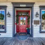 front red door with the address and historic plaque on the building, christmas wreath hanging