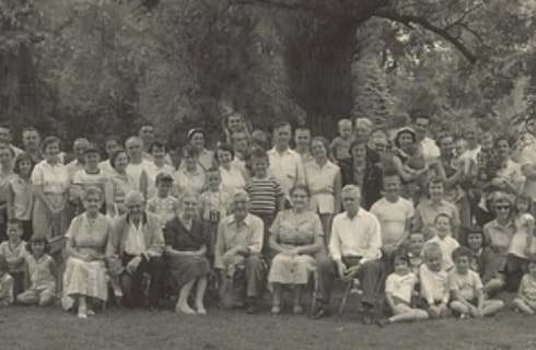 Large group of people from a reunion posing for a picture in a park in black and white