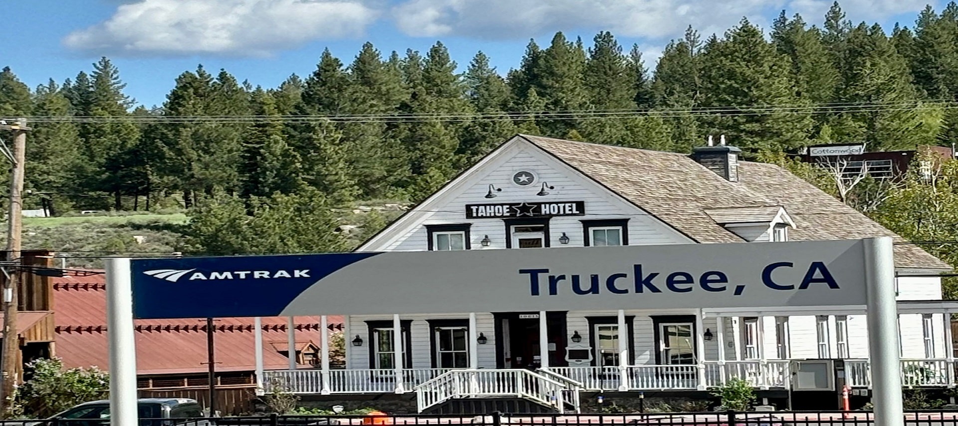 front of the hotel white building with a amtrak truckee ca sign Infront of it