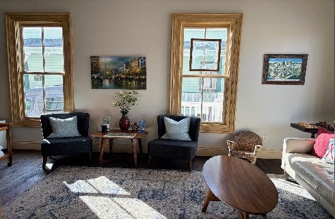 lobby, gathering area two chairs and a small table carpeted floor