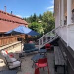 sitting area on the patio side with chairs and an umbrella