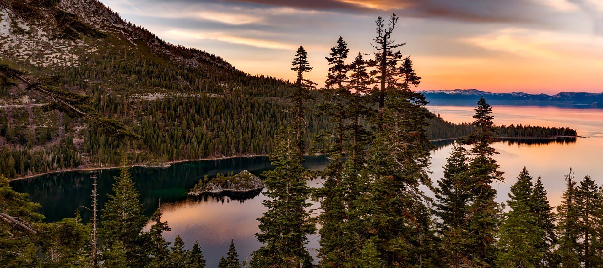 Small water inlet surrounded by a mountain full of green trees at dusk
